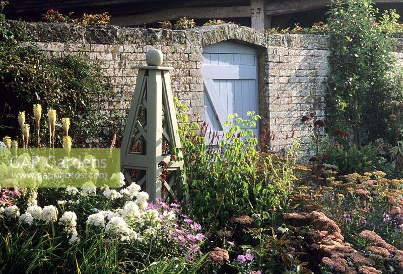 Sussex design Fiona Lawrenson wooden painted obelisks in herbaceous perennial border
