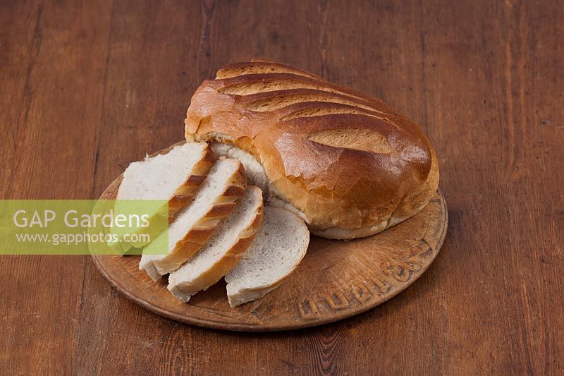 Bloomers white brown wholemeal local fresh loaf bread hand made edible kitchen food breadboard table still life sliced slices