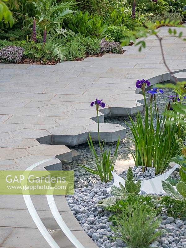 The Manchester Garden. The hexagonal and rectacular  paving adds interest to the water feature and contrast well with the gravel in the water feature.  - Designer: Exterior Architecture. RHS Chelsea Flower Show 2019