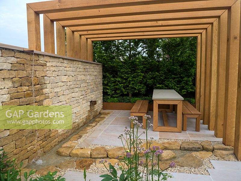 The Kampo no Niwa Garden at the RHS Chelsea Flower Show 2019 with a wooden pergola and stone patio to provide a space from which to view the landscape- Designer: Kazuto Kashiwakura and Miki Sato  - Sponsor: Kampo no Niwa 