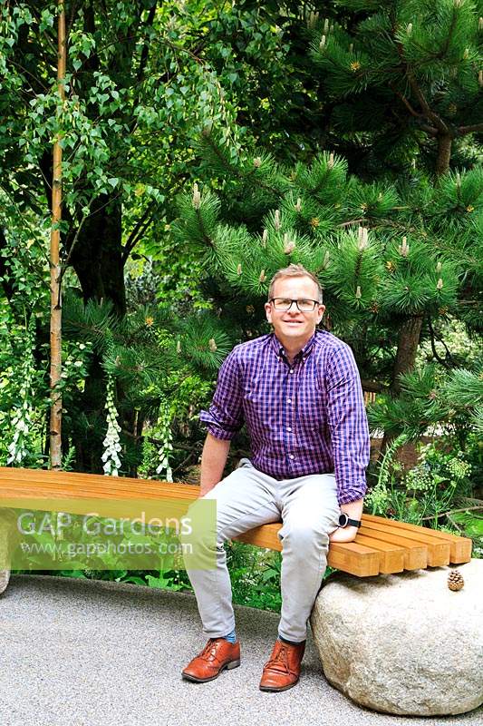 Designer Alistair Bayford sat in his Family Monsters Garden at RHS Chelsea Flower Show 2019. Designer: Alistair Bayford - Sponsor:  idverde, Family Action. Gold medal, Best Artisan Garden.