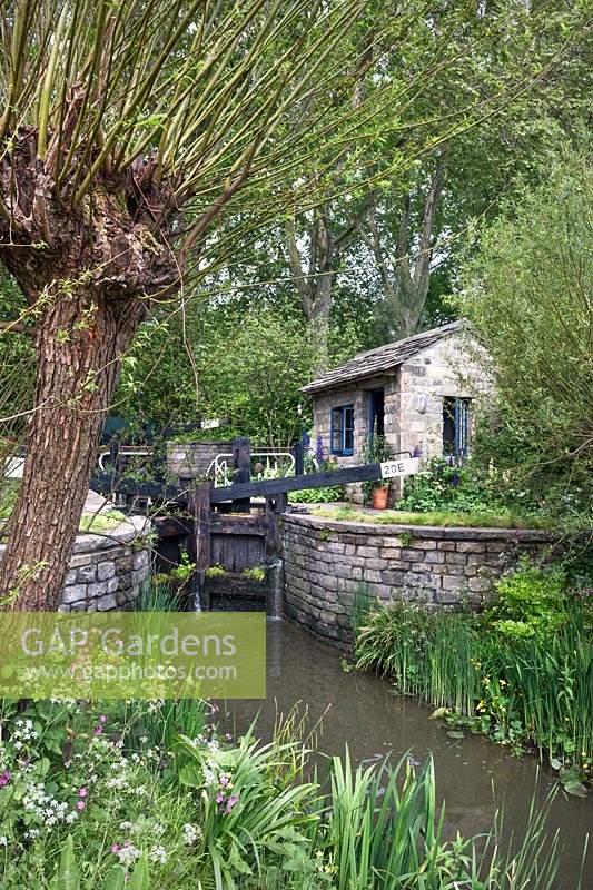 Canal lock and lock keeper's cottage with native flora including red campion and willow, The Welcome to Yorkshire Garden, Design: Mark Gregory, Sponsor: Welcome to Yorkshire, Gold Medal Winner