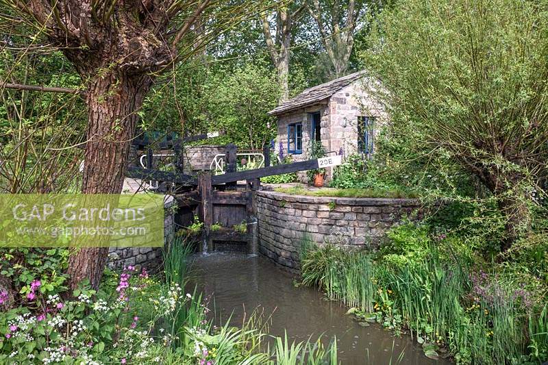 Canal lock and lock keeper's cottage with native flora including red campion and willow, The Welcome to Yorkshire Garden, Design: Mark Gregory, Sponsor: Welcome to Yorkshire, Gold Medal Winner