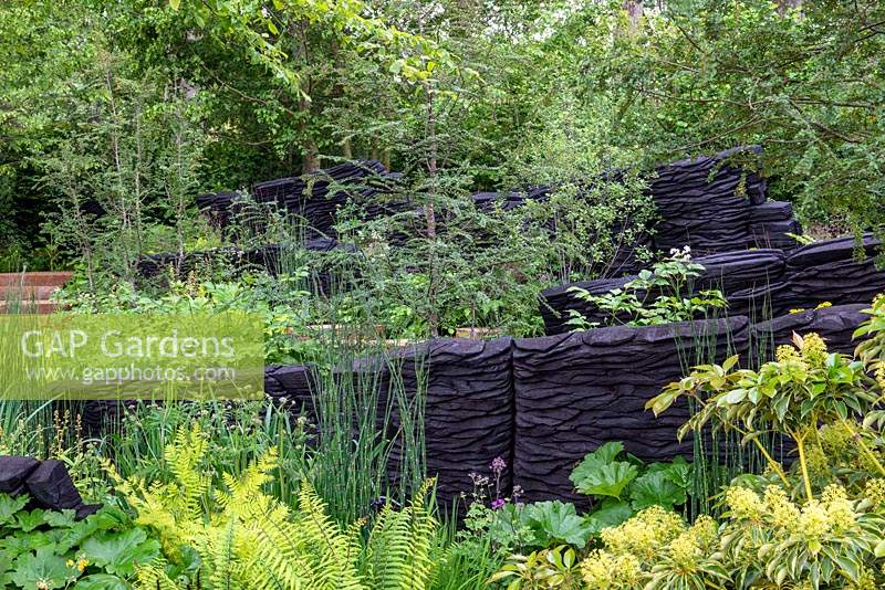 The M and G Garden, RHS Chelsea Flower Show 2019, Design: Andy Sturgeon, Sponsor: M and G - Woodland with blackened timber sculptures by Johnny Woodford. Awarded an RHS Gold Medal. Chelsea Flower Show 2019