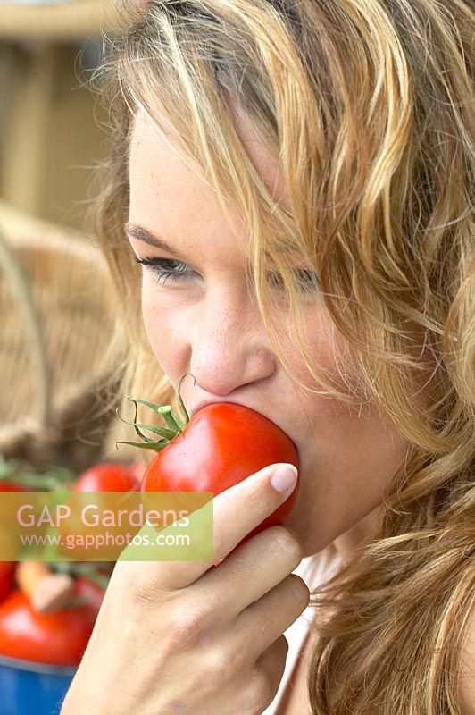 Woman eating tomato