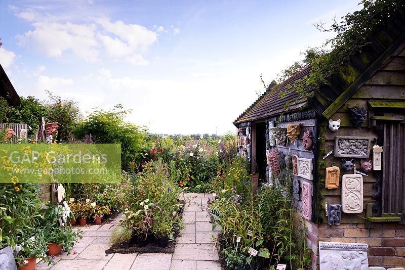 Nursery sales area featuring summer flowering plants and garden plaques. 