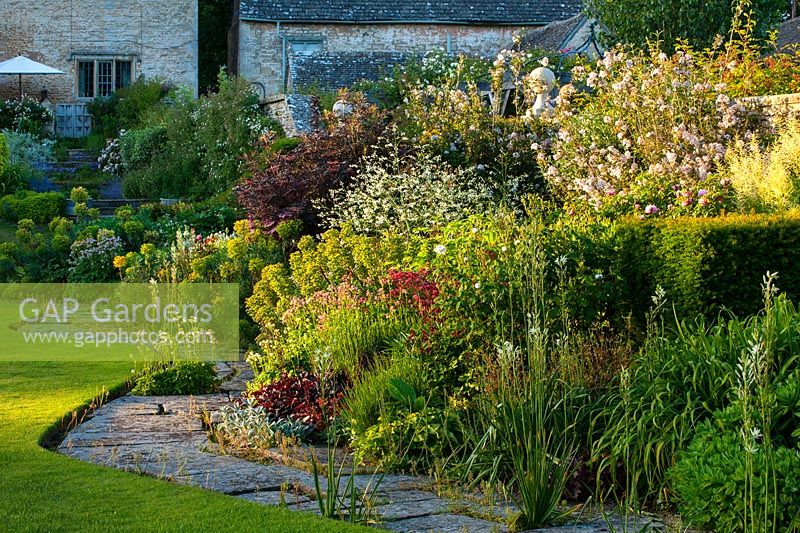 Curving herbaceous border by the lawn - Ablington Manor, Gloucestershire