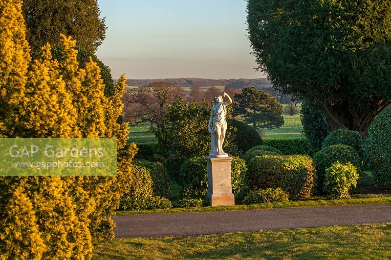 A view of a white statue among evergreen hedging at Brodsworth Hall, Yorkshire. 