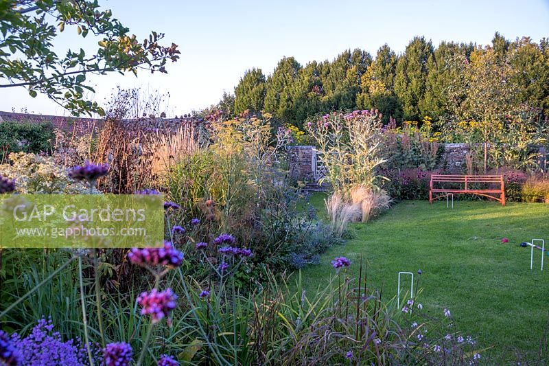 A view of English country garden with flowering perennials and grasses. 