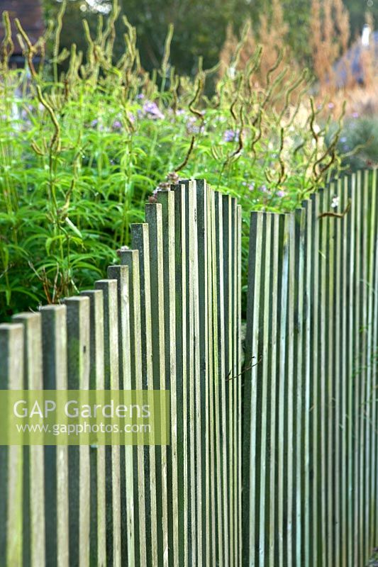 A view of a wavy wooden fence. 