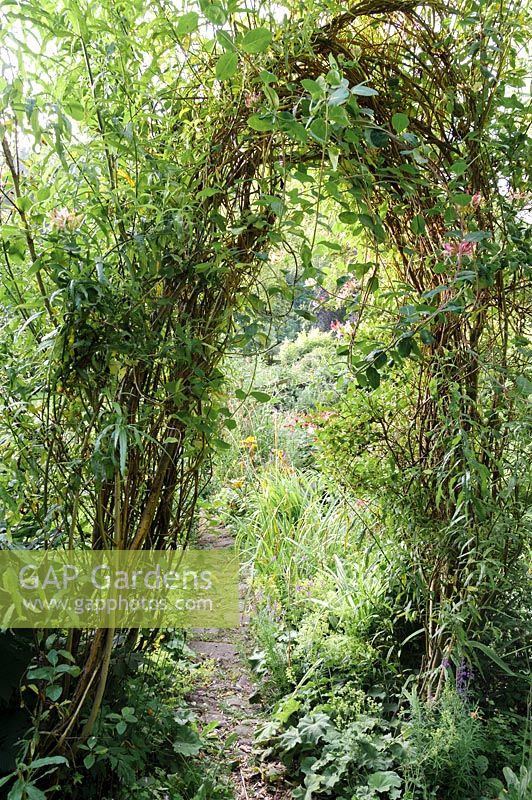 A woven willow arch with path running through. 