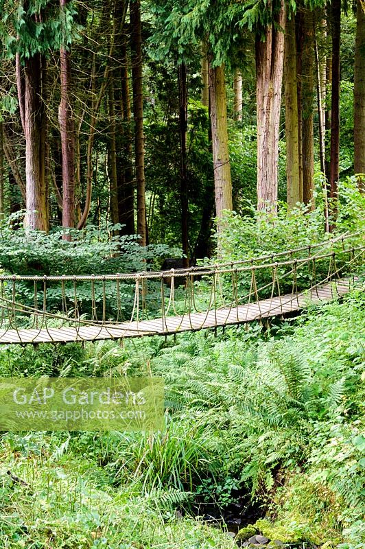 A rope bridge crosses a gully to give access to the garden beyond. 