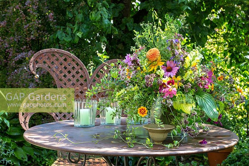 A meta garden table set with summer bouquet. 