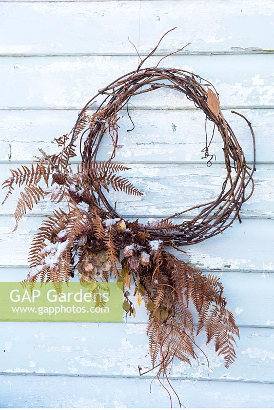 Dried vine wreath decorated with foraged fern leaves and dried seedheads. 