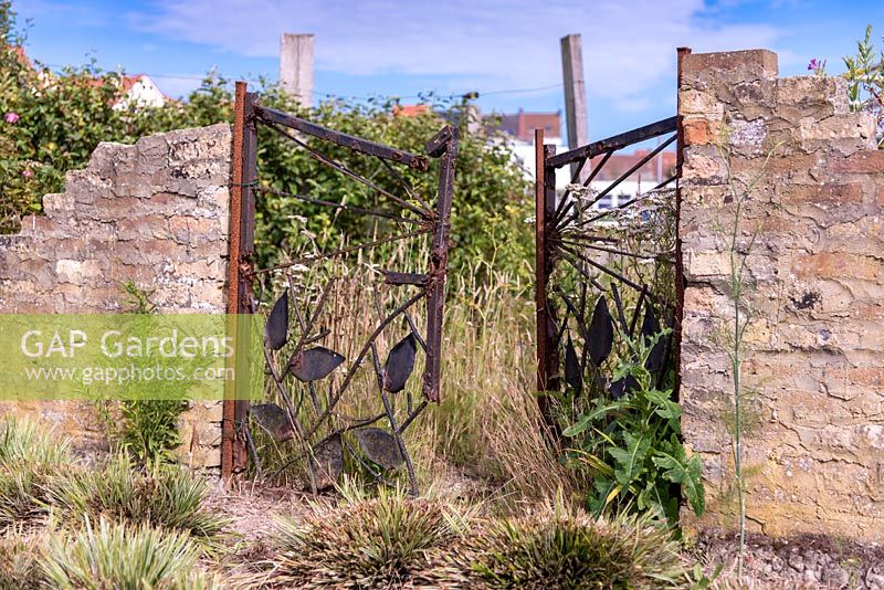 Rusty gate to wasteland garden, France