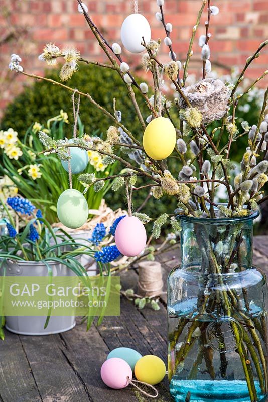 Pastel coloured easter eggs hanging on pussy willow stems. 