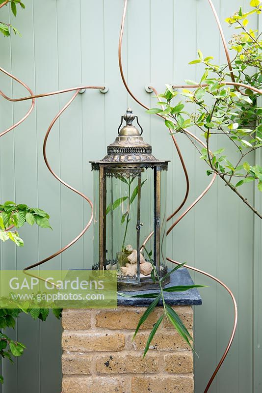 Ornamental lantern on a brick pillar - The Perfumer's Garden, RHS Malvern Spring Festival, 2018.