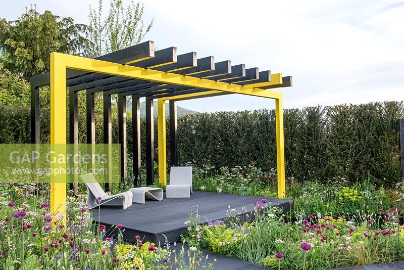 Yellow steel framed pergola with seating area in 'Urban Oasis' garden, RHS Malvern Spring Festival, 2018.