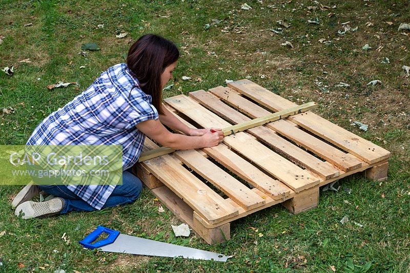 Woman straightening edges to mark a pallet