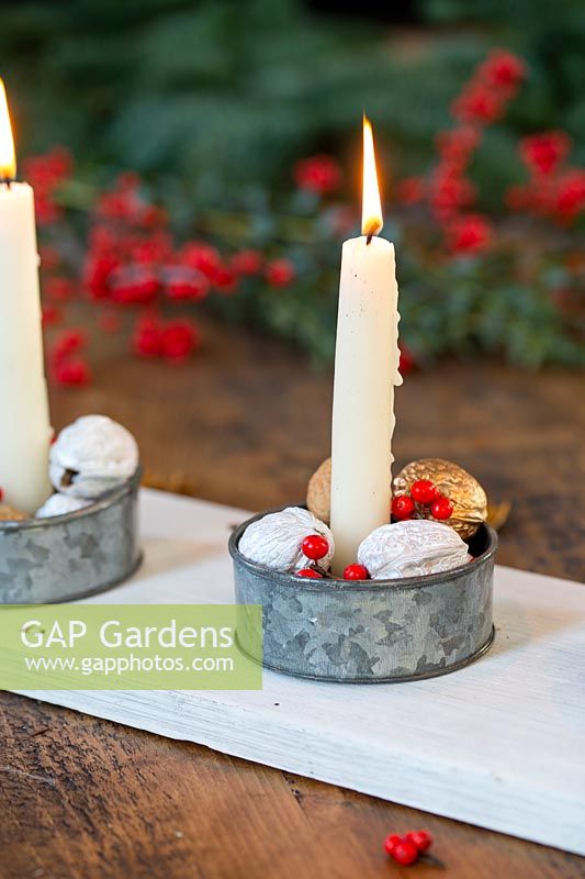 Centrepiece candle holder with gold and white painted walnuts and Ilex berries. 
