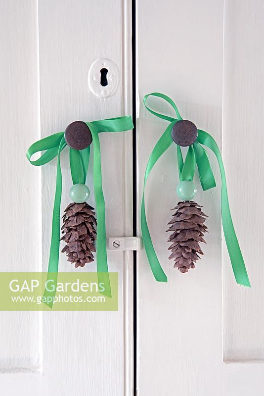 Pine cone decorations hanging cupboard door knobs. 