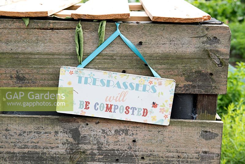 Trespassers with be Composted sign hanging  on compost bin.