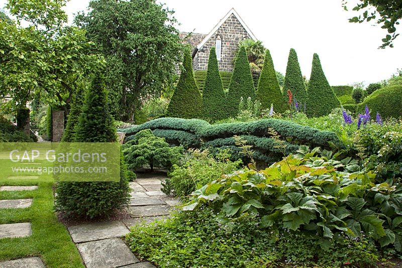 View of formal garden with clipped Taxus baccata topiary at York Gate, Leeds, Yorkshire, UK.