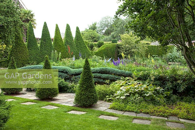 View of formal garden with clipped Taxus baccata topiary at York Gate, Leeds, Yorkshire, UK.

