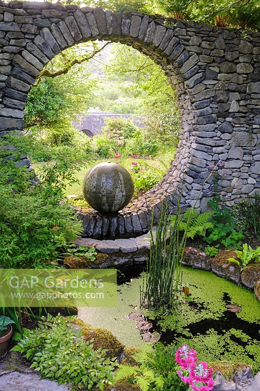 Moon Window in stone wall with cast concrete water feature and circular pool. Fanore, Ireland
