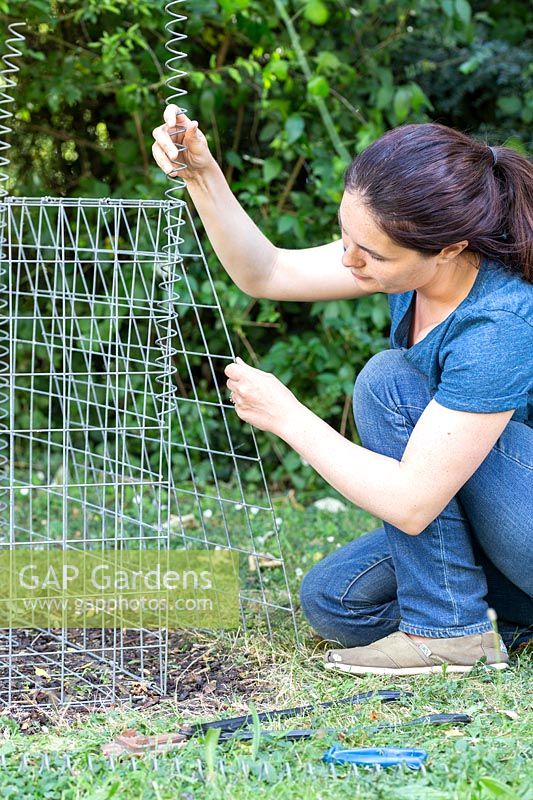 Woman assembling gabion basket using a helical coil spring