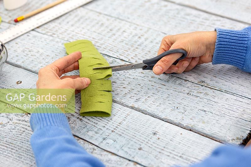 Woman cutting additional slits in felt after unfolding 