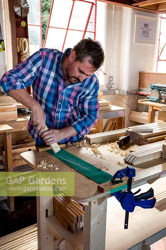 Chris Punch, garden furniture designer, in his workshop preparing wood. 