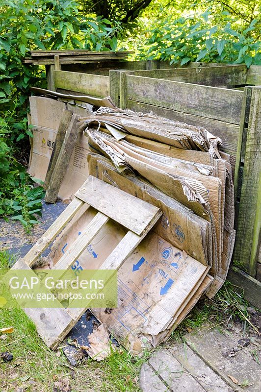 Cardboard stacked ready to use in the many compost bins in the garden.