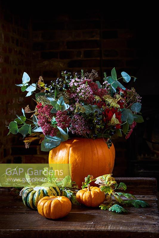 Pumpkin vase with flowers and foliage