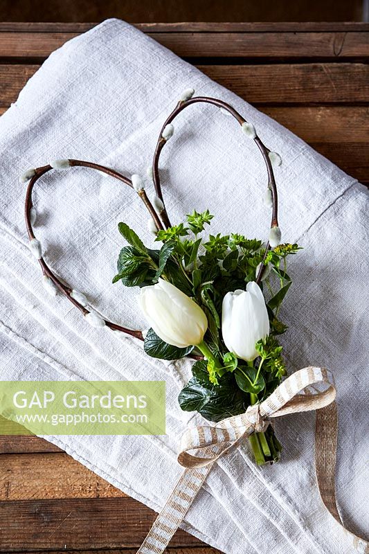 Spring floral arrangement with willow stem heart with white Tulips, greenery and ribbon