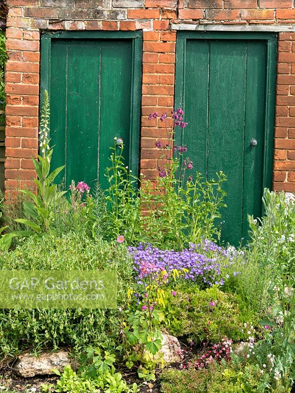 Cottage garden with red brick outside privvy.