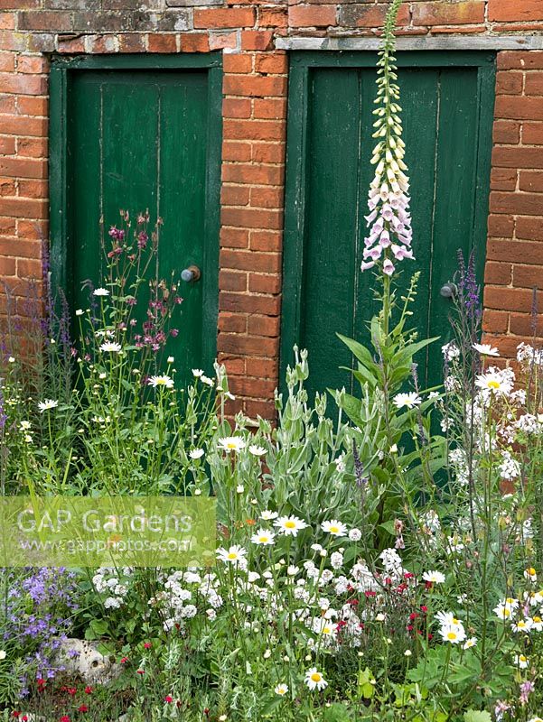 Cottage garden with red brick outside privvy.