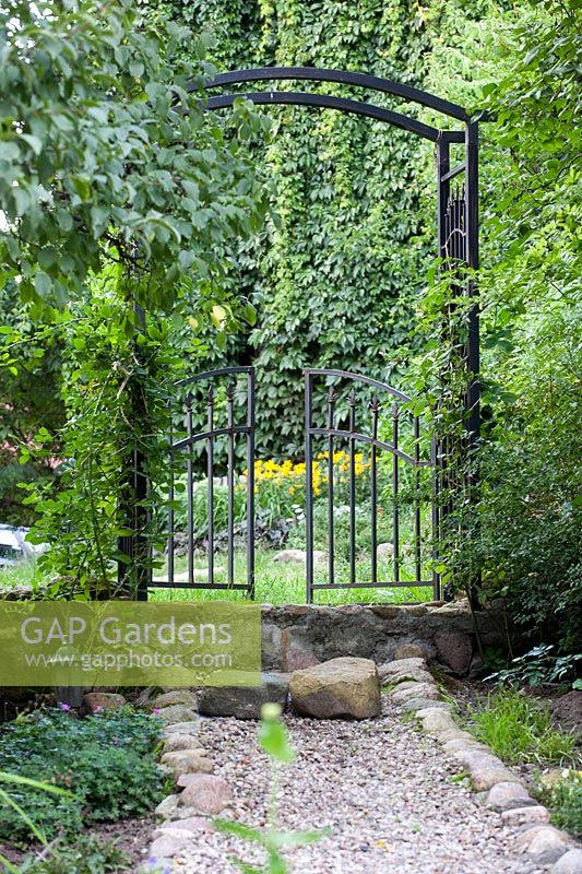Steel gate with arch at garden entrance 