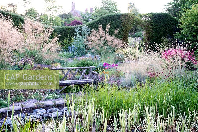Colourful flowering perennial border, includes Stipa gigantea and Helictotrichon sempervirens, Bluebell Cottage Gardens, Cheshire, UK