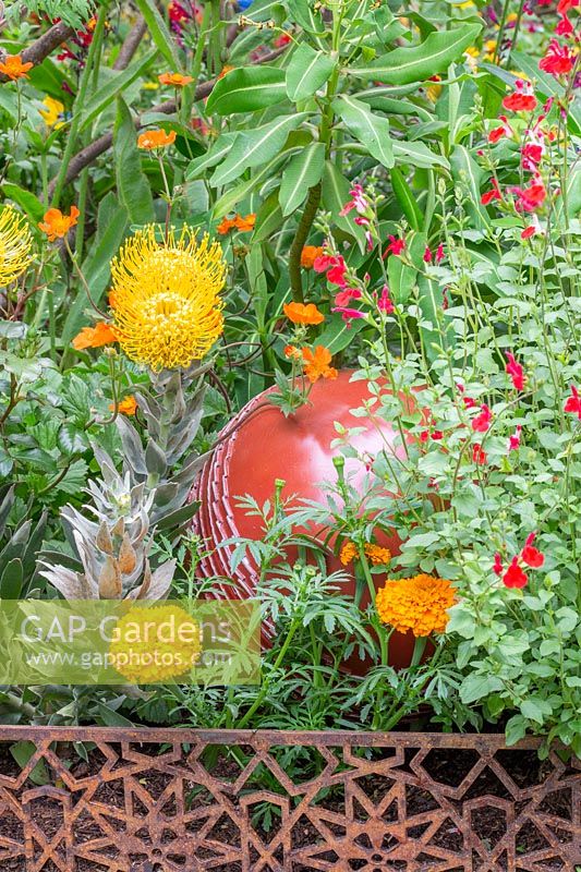 Mixed colourful planting and cricket ball sculpture in The British Council Garden - India: A Billion Dreams. Sponser: British Council, RHS Chelsea Flower Show, 2018.
