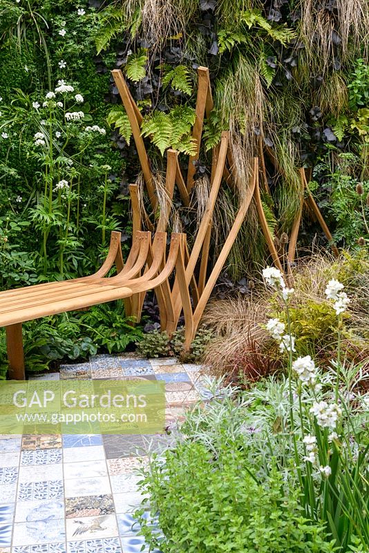 Bench and ceramic tile path. The Embroidered Minds Epilepsy Garden. Sponsor: Embroidered Minds, RHS Chelsea Flower Show, 2018.
