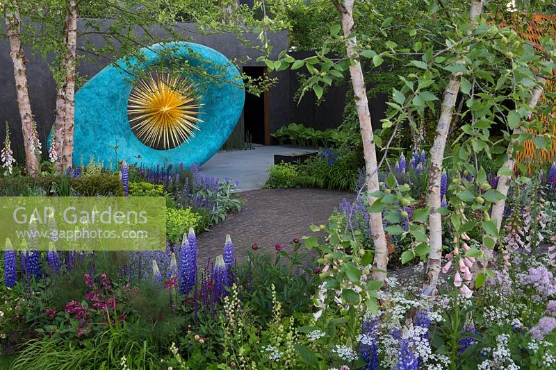 Sculpture surrounded by mixed planting in The David Harber and Savills garden, Sponsor: David Harber and Savills. RHS Chelsea Flower Show, 2018.