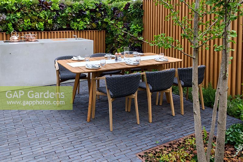 Outdoor cooker, edible living wall and table and chairs. Urban Flow garden, Sponsor: Thames Water, RHS Chelsea Flower Show, 2018.