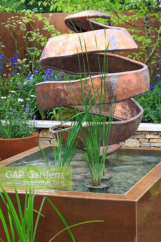 The Silent Pool Gin Garden - Citrus Peel copper sculpture by Giles Rayner in corten steel, infinity-edged pool - Sponsor: Silent Pool Distillers - RHS Chelsea Flower Show 2018