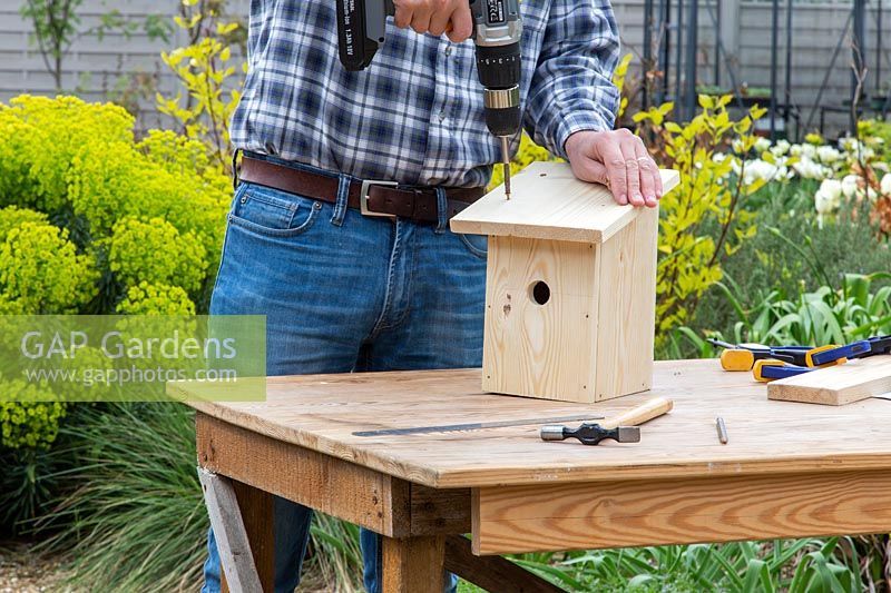Using electric screwdriver to fix roof to bird box