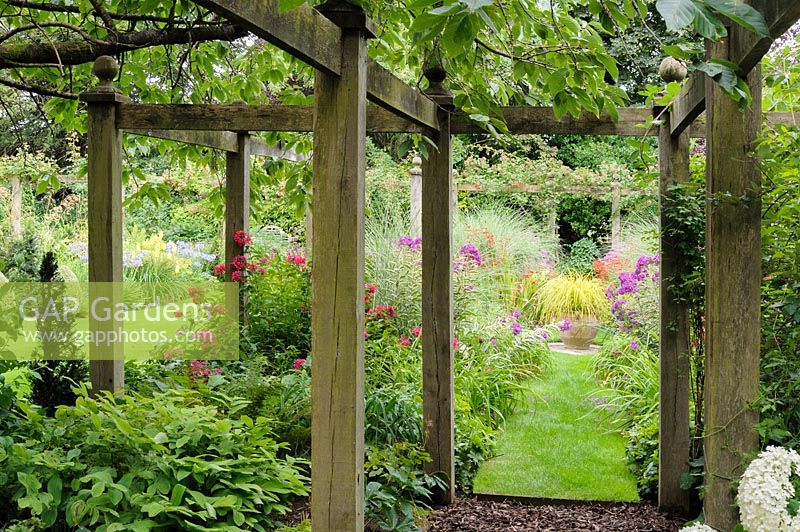 Wooden pergola with Miscanthus and Phlox, Wiltshire, England, UK