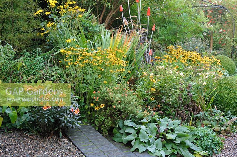 Colourful mixed planted border with metal and glass sculpture by Straysparks - Shropshire, UK
