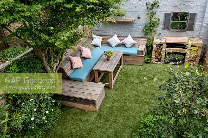 Courtyard garden with artificial lawn and reclaimed scaffold board seating, West London 