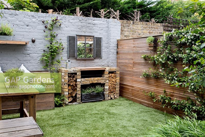 Courtyard garden in West London with artificial lawn, brick barbecue and Cedar battened Trellis