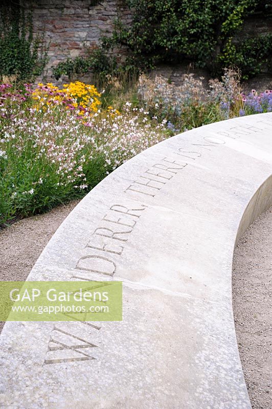 40' stone bench in the Garden of Reflection inscribed with the words 'Wanderer, 
there is no path, the path is made by walking' from a poem by Antonio Machado